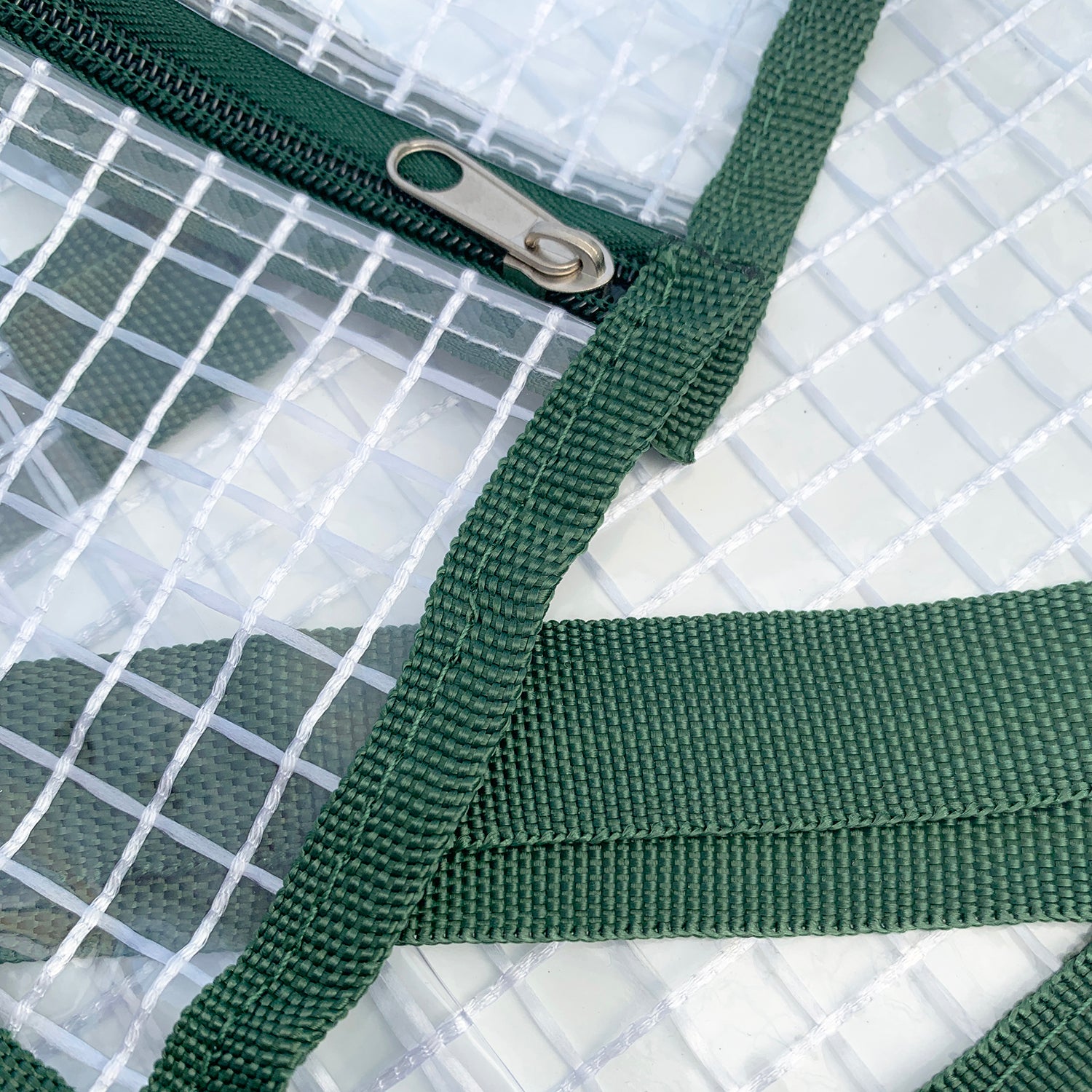 A clear plastic greenhouse cover with dark green edging, designed to fit on an indoor plant stand.